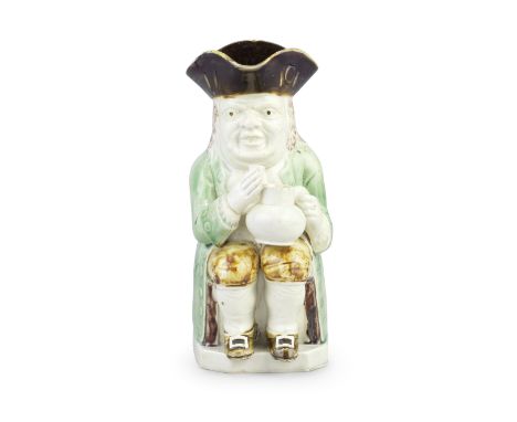 A small Wood Family Toby jug, circa 1790Of 'Mould 51' type, seated and holding a jug in his left hand, a glass in his raised 