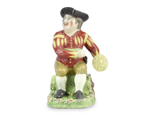 A rare Staffordshire 'Prince Hal' Toby jug and cover, circa 1820Modelled as a portly figure seated on a rock, head turned and