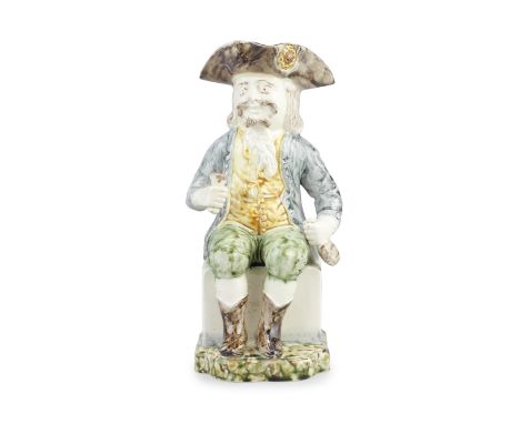 A Portuguese creamware 'Sailor' Toby jug, circa 1790-1800In English style, modelled seated with a bottle in his left hand and
