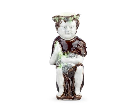 A very rare creamware 'Bacchus' jug, circa 1785-90Bacchus modelled seated on a barrel with his feet resting on a shallow step