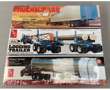 Three AMT 1:25 scale plastic model kits, all trailer units: 628 Peerless Roadrunner Logging Trailer; 684/06 Plated Tanker; 64