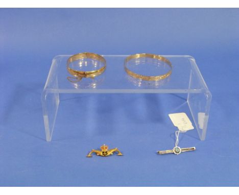 A 14k 'slave' Bangle,  engraved with scrolling foliate in black enamel 'Kolina', 17g; a hinged bangle, the front engraved in 