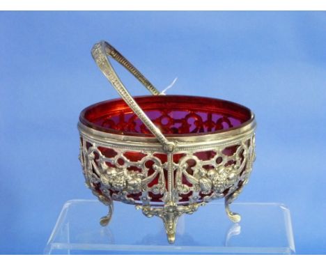 A Victorian silver-plated and cranberry glass Sugar Bowl, of pierced ovoid form with swing-handle and four shell-capped brack