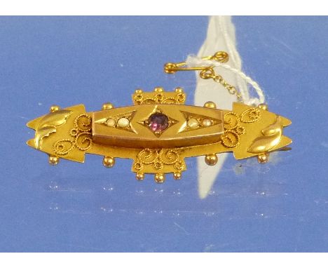A 9ct yellow gold Bar Brooch of plaque shaped form, the centre set small ruby and four seed pearls, in (5cm)