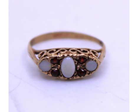 9ct Yellow Gold Opal and Garnet Ring.  The ring contains an Oval Cabochon Opal in the centre that measures approx. 4.76mm len