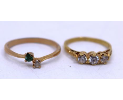 Two Gold Dress Rings. To include an 18ct Yellow Gold White Zircon Three-Stone Ring and a 10k Yellow Gold Emerald and Cubic Zi