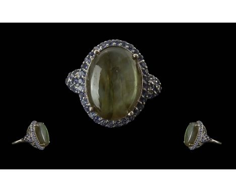 Labradorite and Iolite Statement Ring, an 18ct oval cut cabochon of top quality labradorite, showing a magnificent display of