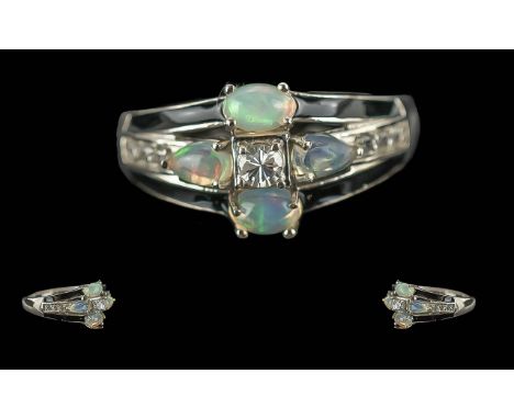 Art Deco Style Opal and Black Enamel Ring, four cabochon cut opals set in a floreat fashion, centred by a round cut white nat
