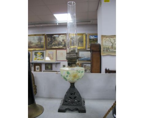 A Late XIX Century Oil Lamp, the opaque glass reservoir painted with flowers, raised on a pierced cast iron base, chimney pre