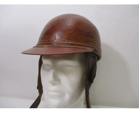 A Cromwell protective headwear racing car helmet with a brown hard hat and peak and stitched leather ear and neck guard, with