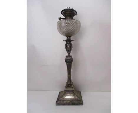 A late Victorian silver plated oil lamp having a clear glass reservoir with line cut decoration, over a baluster and square c