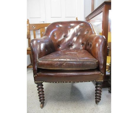 A late 19th century brown leather, button upholstered armchair with a cushion seat, raised on, faux rosewood, bobbin turned f