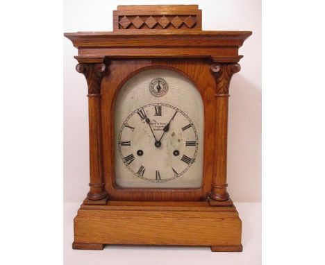 Fattorini & Sons Ltd, Westgate Bradford, A German mantle clock in a carved light oak case, having a white painted Roman dial 