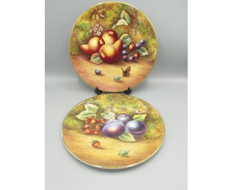 Pair of C20th porcelain plates, hand painted with summer fruits by J Skerrett (ex Royal Worcester), with gilt outline 