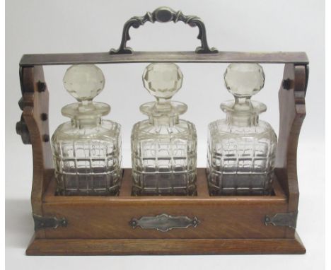 C19th or early C20th tantalus, with three cut glass decanters mounted in an oak and silver plate mounted frame, L36cm D13cm H