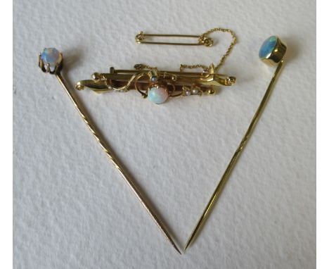 A Victorian 15ct opal and seed pearl brooch, on scrolled bar with central round opal cabochon, weight 3.5g, together with two