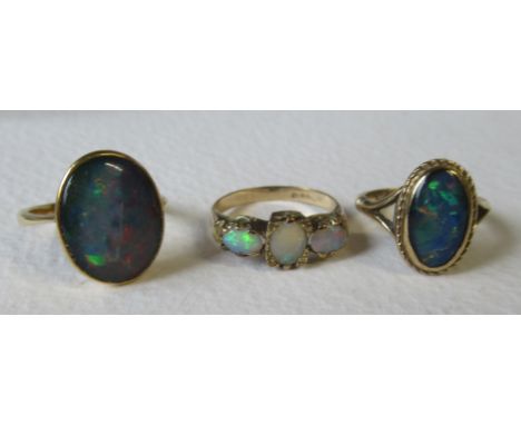 A three stone opal ring, together with two rings, 9ct and 18ct, set opal claws