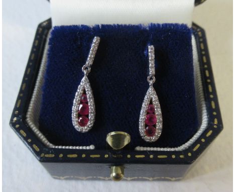 A pair of 18k white and yellow gold ruby and diamond drop earrings, the leaf shape drop set three graduated round-cut rubies 