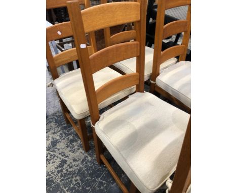 A SET OF OAK MODERN LADDER BACK DINING CHAIRS WITH SOLID SEATS AND SQUAB CUSHIONS.