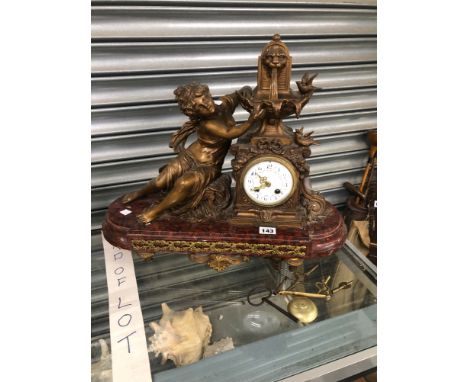 A LATE 19th CENTURY CLOCK SURMOUNTED BY A FOUNTAIN WITH A SPELTER LADY TO ONE SIDE SEATED ABOVE THE MOTTLED RED MARBLE PLINTH