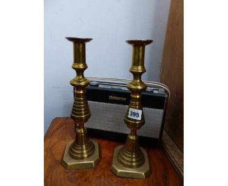 A PAIR OF BRASS CANDLESTICKS AND A VINTAGE RADIO. 