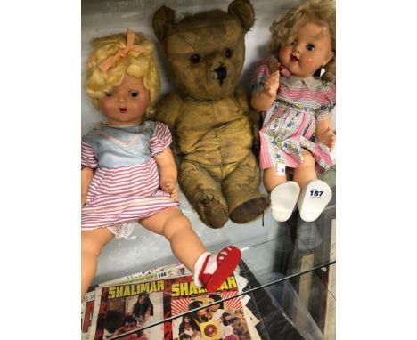 TWO VINTAGE PLASTIC DOLLS TOGETHER WITH A TEDDY BEAR AND A COLLECTION OF TOY CARS IN DISPLAY CASE.