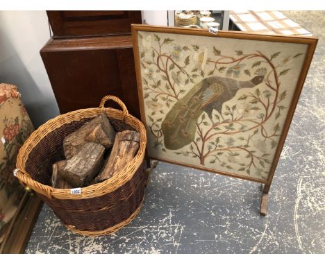 A WICKER LOG BASKET WITH LOGS AND A FIRE SCREEN.