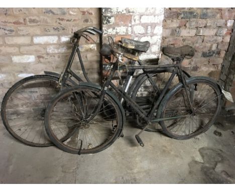 Three vintage bicycles, one Hercules black painted, one green painted, one with wicker basket.