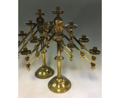 A pair of brass altar candlestick holders, with two adjustable branches holding seven lights, heights 48cm.