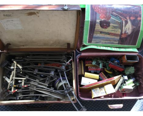Two suitcases containing Chad Valley clockwork train set, including engines, carriages, stations, track, etc.