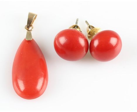 A part-suite of coral jewellery, comprising a pear cut coral cabochon pendant and a pair of button cabochon earrings, unmarke