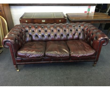 An ox blood three-seater leather Chesterfield style sofa with button back.