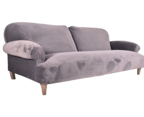 A large contemporary designer four seater sofa settee. The sofa having a scrolled back and armrests with all upholstered in a
