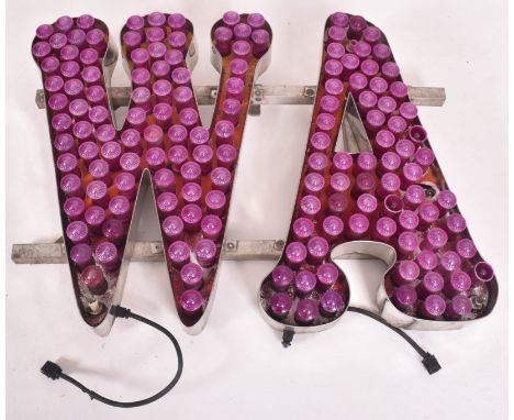 A vintage funfair / fairground / amusement park flashing light sign in the form of letters. The purple flashing lights formin