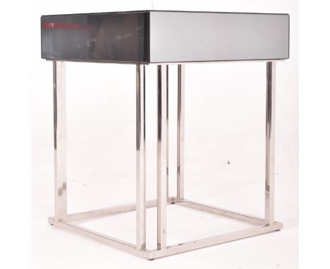 A contemporary designer side table / occasional lamp table. The table of square form having a mirrored top and sides raised o