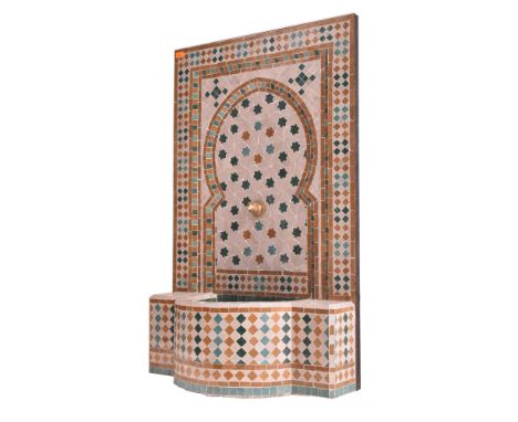 A Moroccan vintage handmade mosaic garden outdoor fountain. The fountain having a tiled surface with decorative back and dome