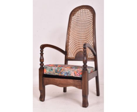 A vintage 20th century Art Deco cane-backed armchair / low bedroom chair. The chair having an arched cane-woven backrest with