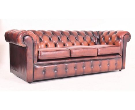 A retro late 20th century oxblood leather button back Chesterfield three seater sofa settee. The sofa having a buttoned back 