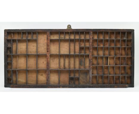 An early 20th century circa 1930s printer's drawer, having been adapted to wall hanging as a display case. Featuring three di