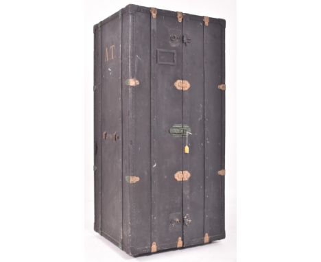 A large early 20th century shipping trunk / travel chest / cargo wardrobe. Bounded suitcase front, having a domed top and bra