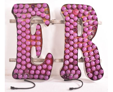 A vintage funfair / fairground oversized flashing light sign. The sign with purple lights forming letters E &amp; R. Letters 