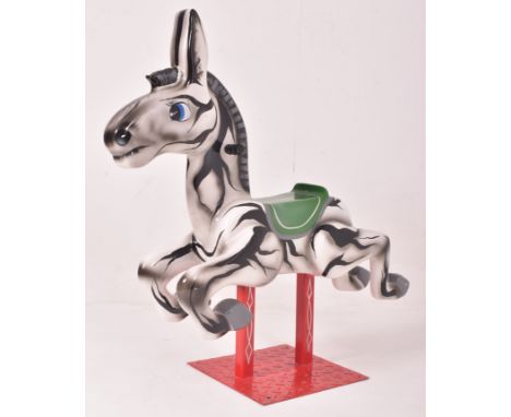 A vintage 20th century fair ground / funfair / amusement park juvenile ride in the form of a zebra. The ride with green seat,