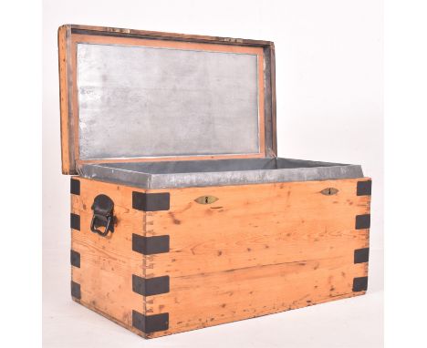 A 20th century mercantile pine and iron bound travel trunk / chest. The chest of simple form having a hinged cover opening to