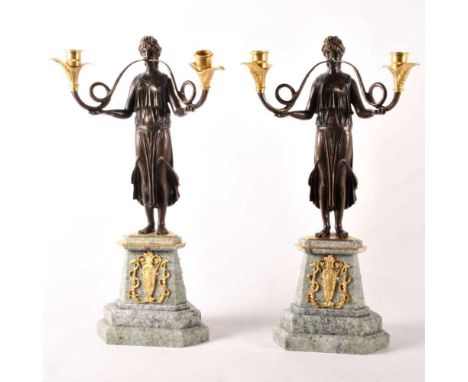 A pair of Empire style bronze and gilt twin branch candelabra, 20th century, each in the form of a figure with outstretched a