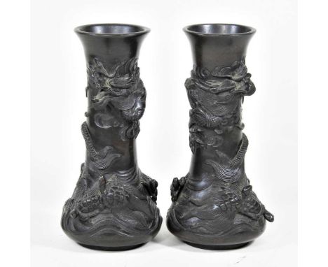 A pair of Chinese bronze vases, 20th century, each decorated in relief dragons, 21cm high (2)