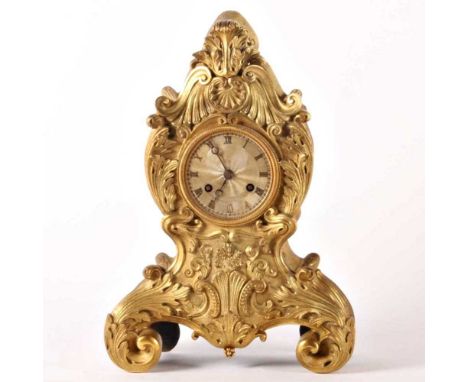 A 19th century gilt metal mantel clock, in the Rococo taste, with Roman hours, having an eight day movement striking on a bel