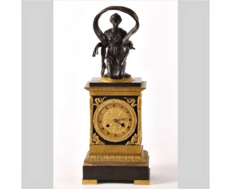 A 19th century French Empire mantel clock, surmounted by a bronze figure of a lady, having an eight day movement, 49cm high