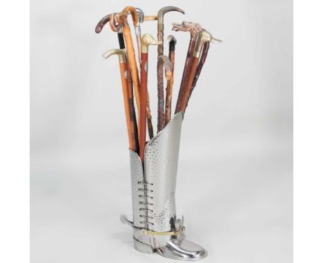 A novelty stick stand, in the form of a boot, together with a collection of walkling sticks