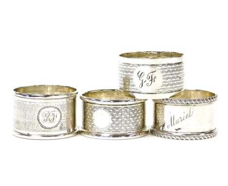 Four various silver napkin rings, comprising a napkin ring with engine turned decoration and bearing the initials GF, Birming