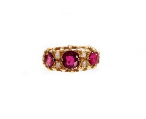 A ruby and diamond set gypsy ring, set with three oval rubies, and four tiny diamonds, each in claw settings yellow metal sta